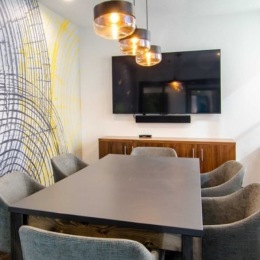 a room with a table, chairs and a tv