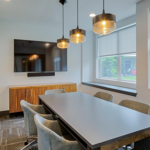 a room with a table, chairs and a tv