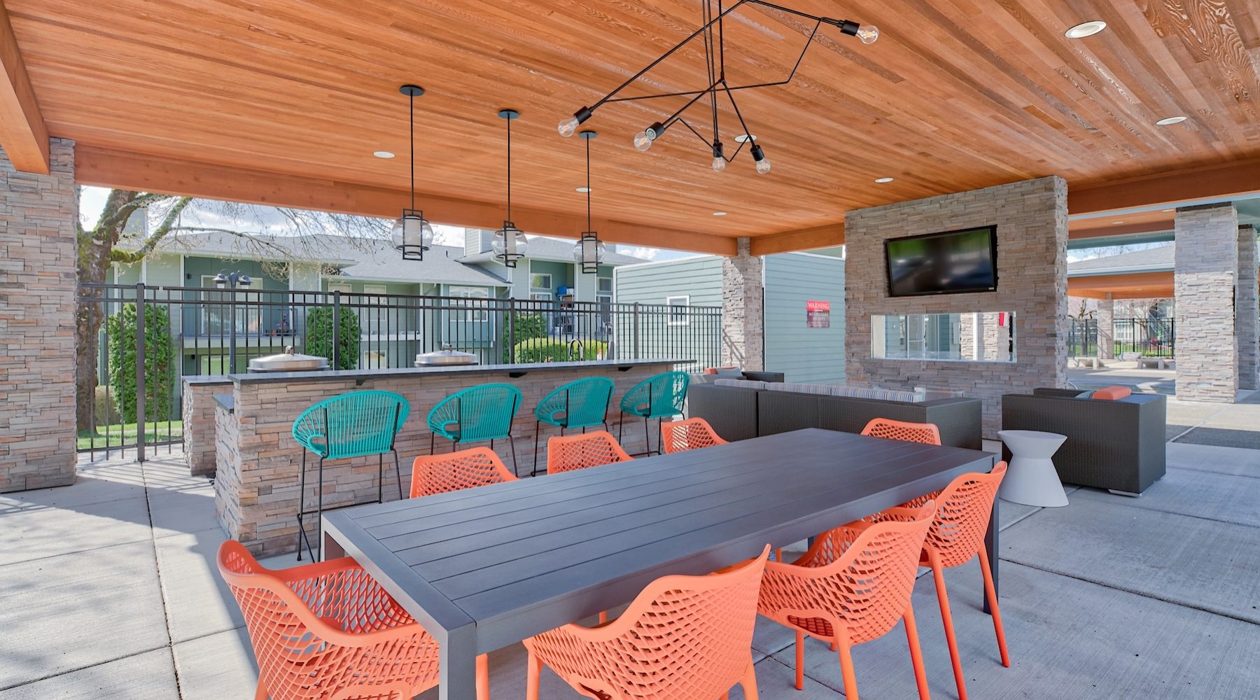 a patio with tables, chairs and a tv