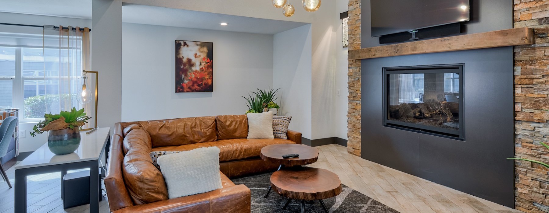 a clubroom with a couch, tv and a fireplace